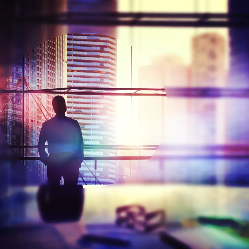 Man looking out of office windows with blurry surroundings