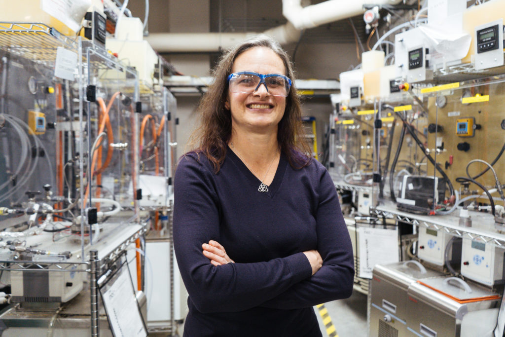 Kathy Ayers, engineer at Nel Hydrogen smiling in front of machinery