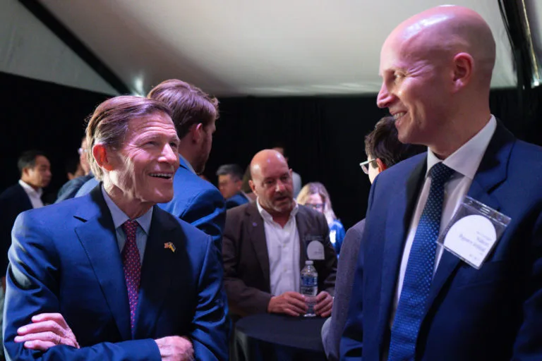 CEO Håkon Volldal and Senator Richard Blumenthal smiling at each other in a crowd